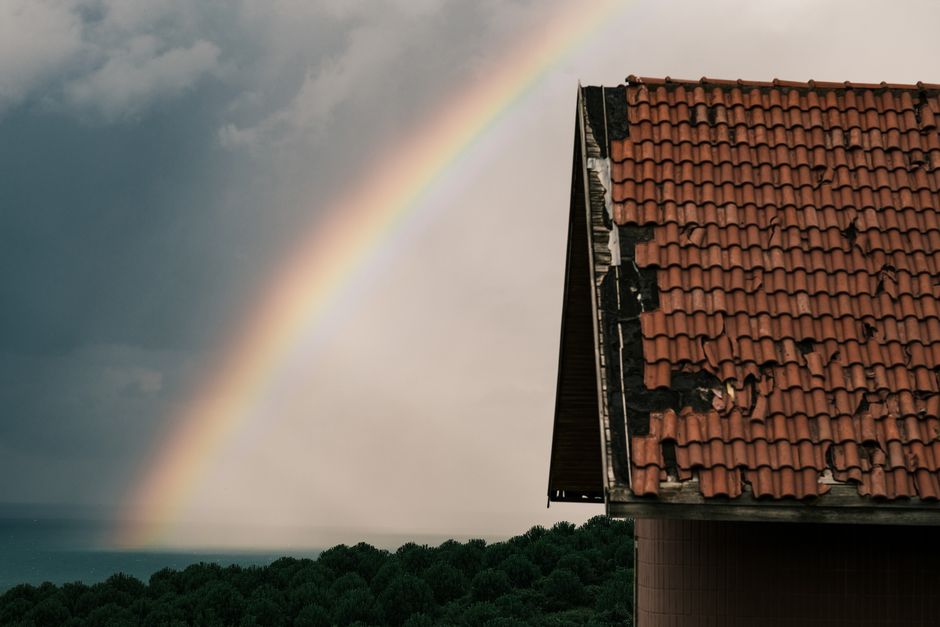Storm-damaged roof with cracked and displaced asphalt shingles